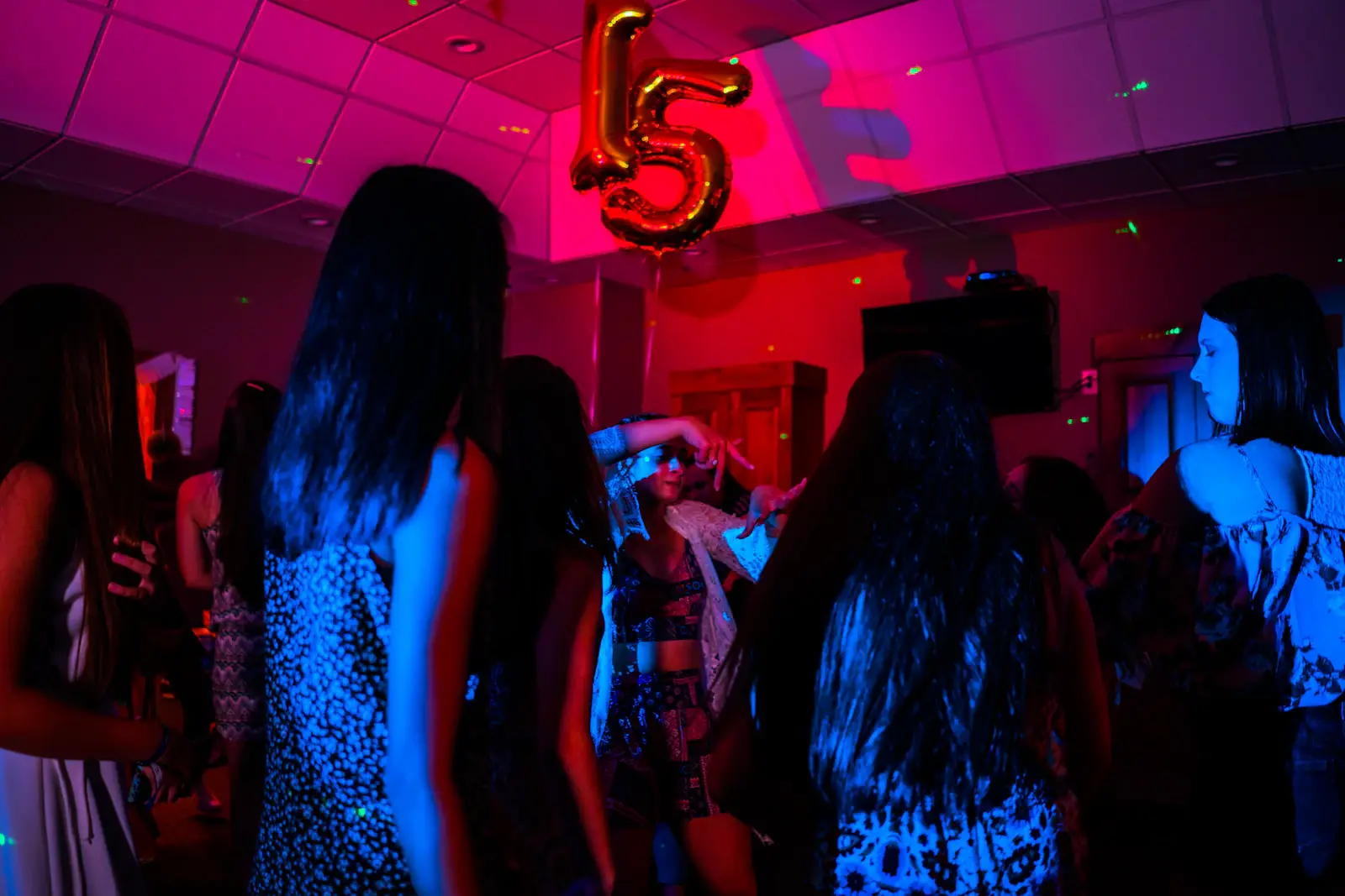 Birthday crowd dancing under neon lights
